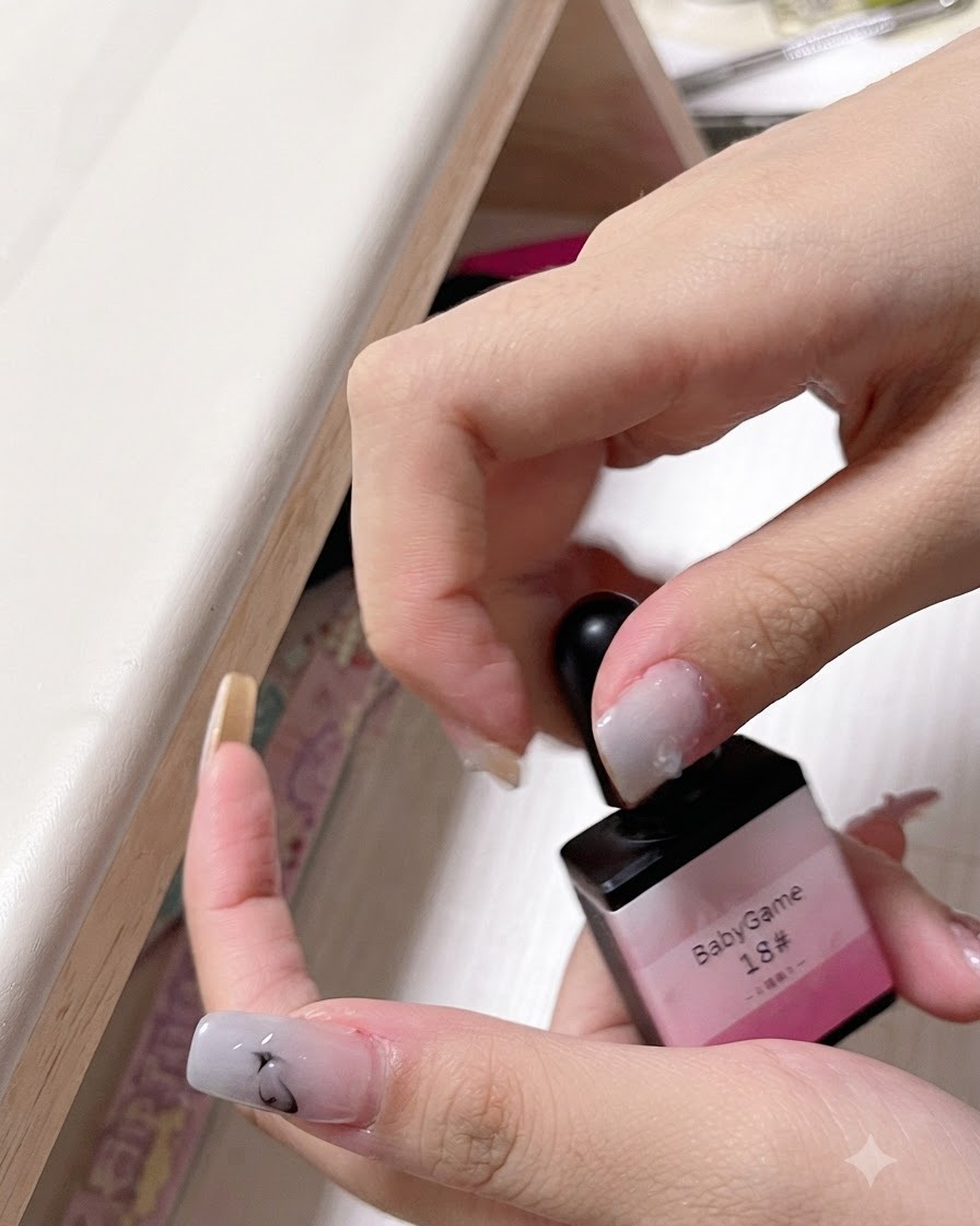 A hand holding up a bottle labeled bbg spray gel number 18 showing its pink color.