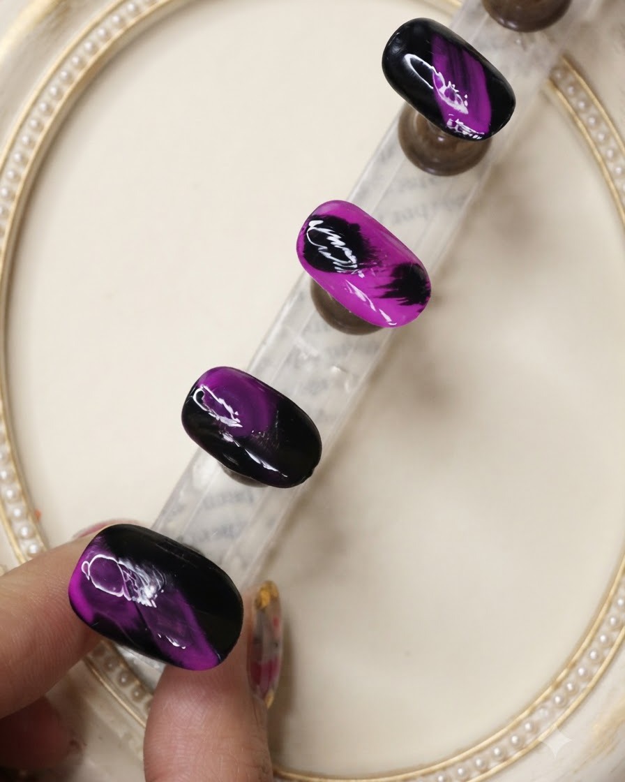 A top coat brush applying a protective layer over the textured black and neon purple nail designs.