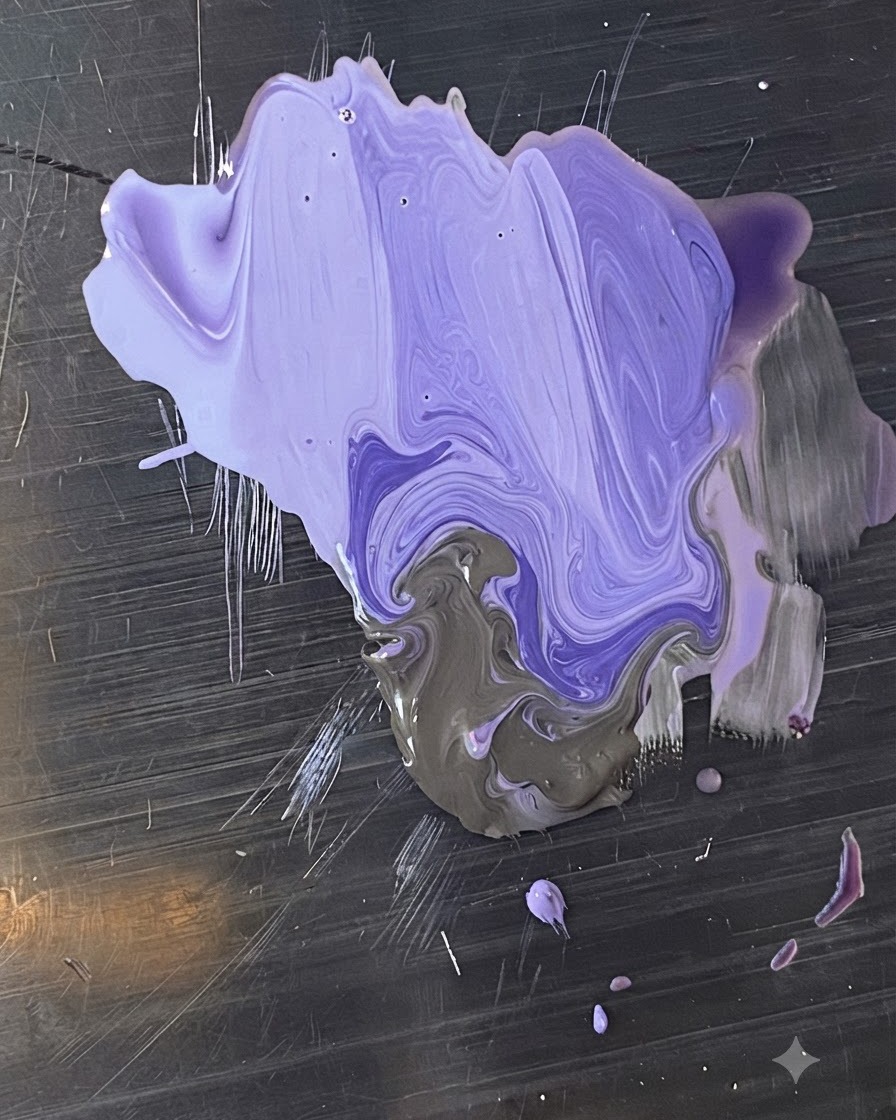 A metal palette with blended shades of purple and grey gel polish being mixed by a brush.