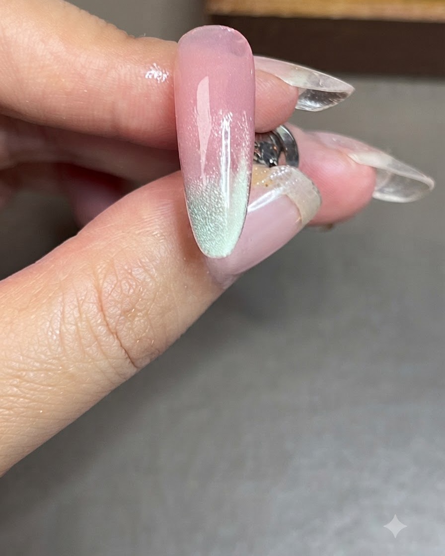 A nail with a finished blue cat-eye side stripe after being cured under a lamp.