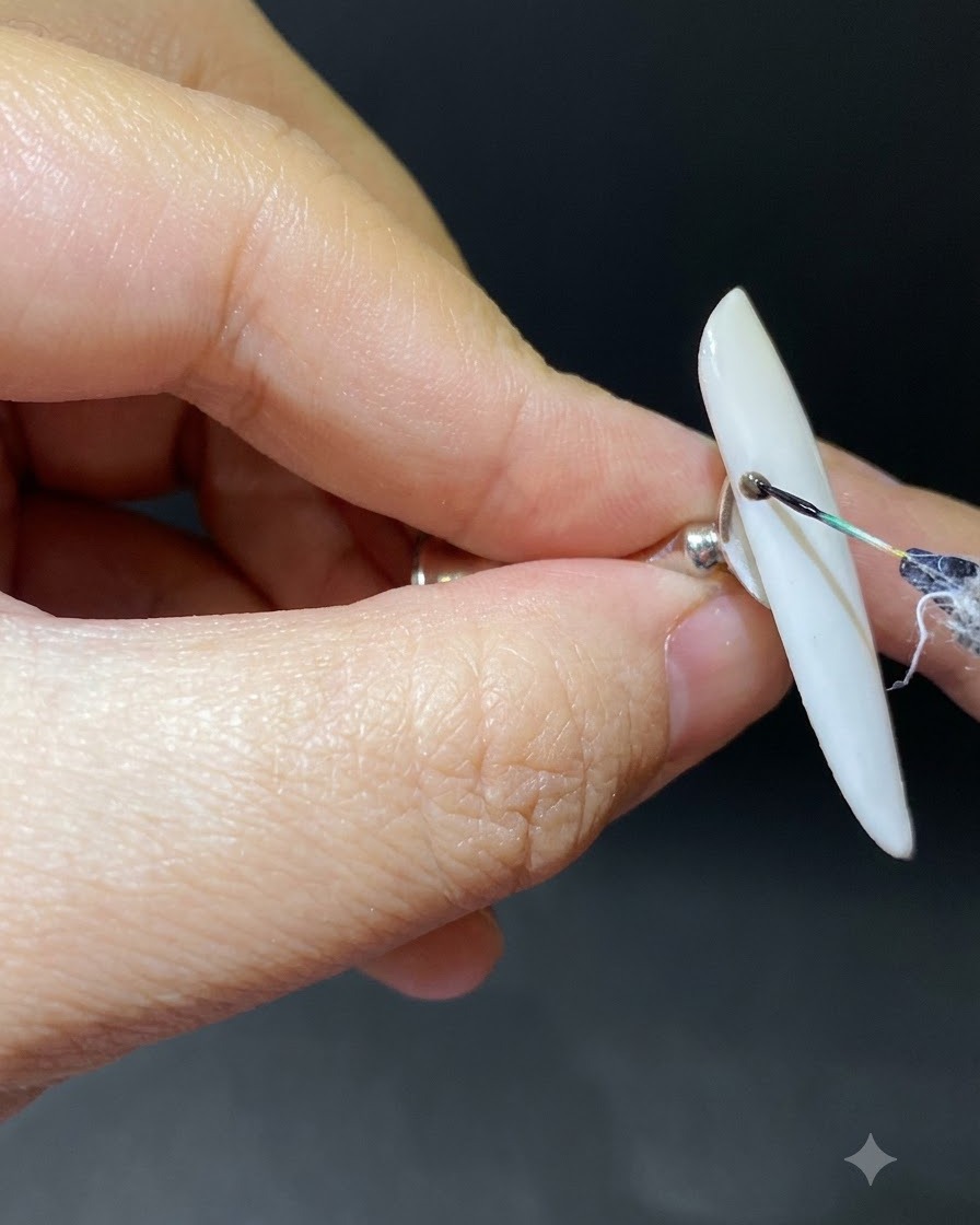 A fine liner brush drawing a dark curved branch from the cuticle on a gradient nail.