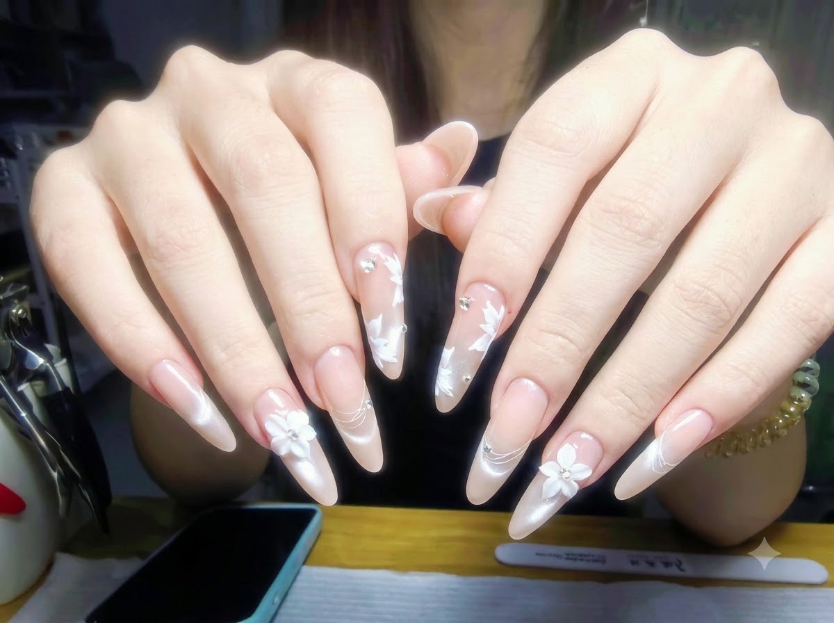 Hands resting on a manicure table with nail polish bottles and professional tools arranged neatly in the background.