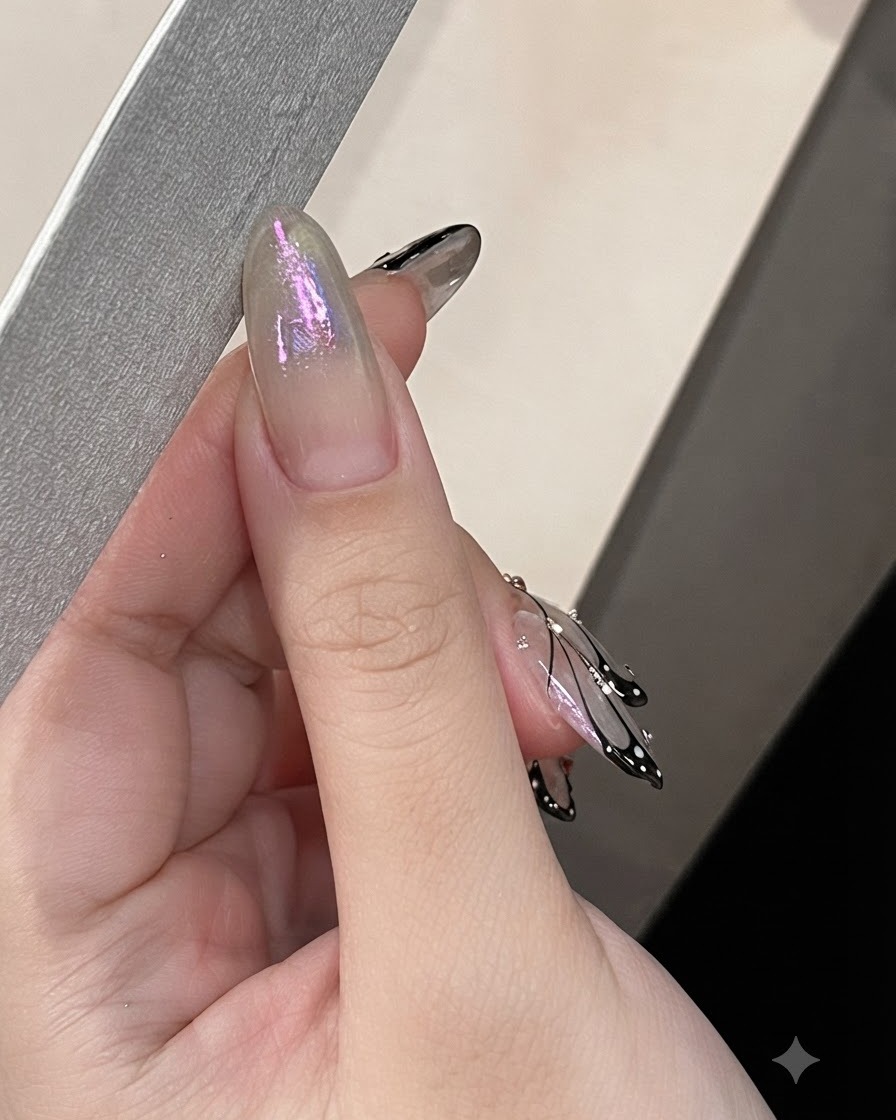 A hand using a nail file along the side edge of an almond-shaped nail.