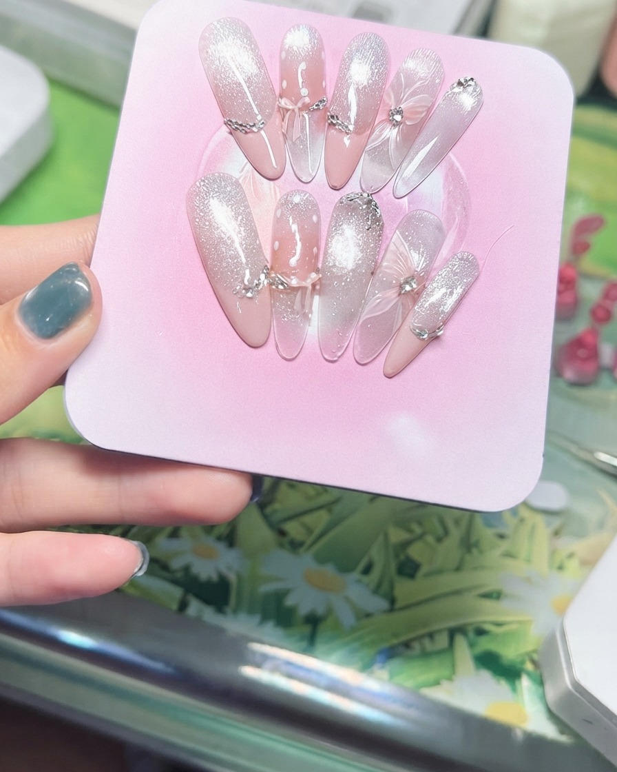 A hand tilting a pink display board to showcase the sparkling magnetic cat eye particles catching light.