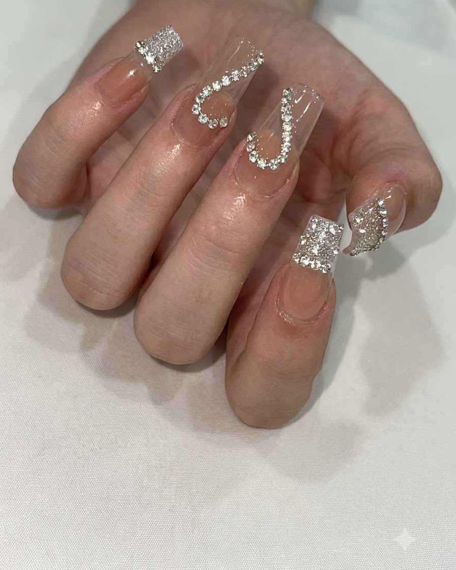A hand positioned under a compact UV/LED nail lamp to cure detailed nail art.