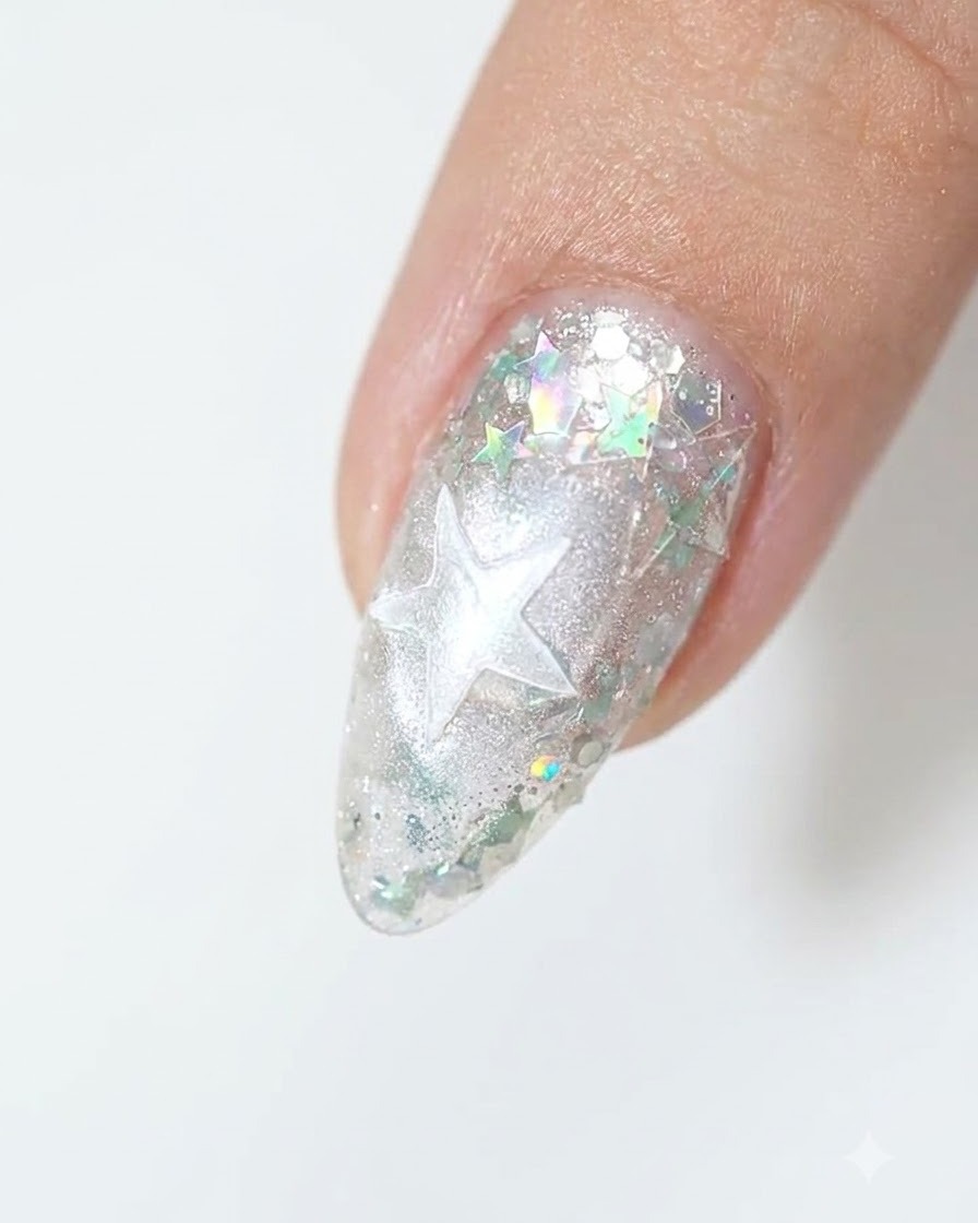 A close-up of a fingertip showing a star outline layered over a shimmery silver base.
