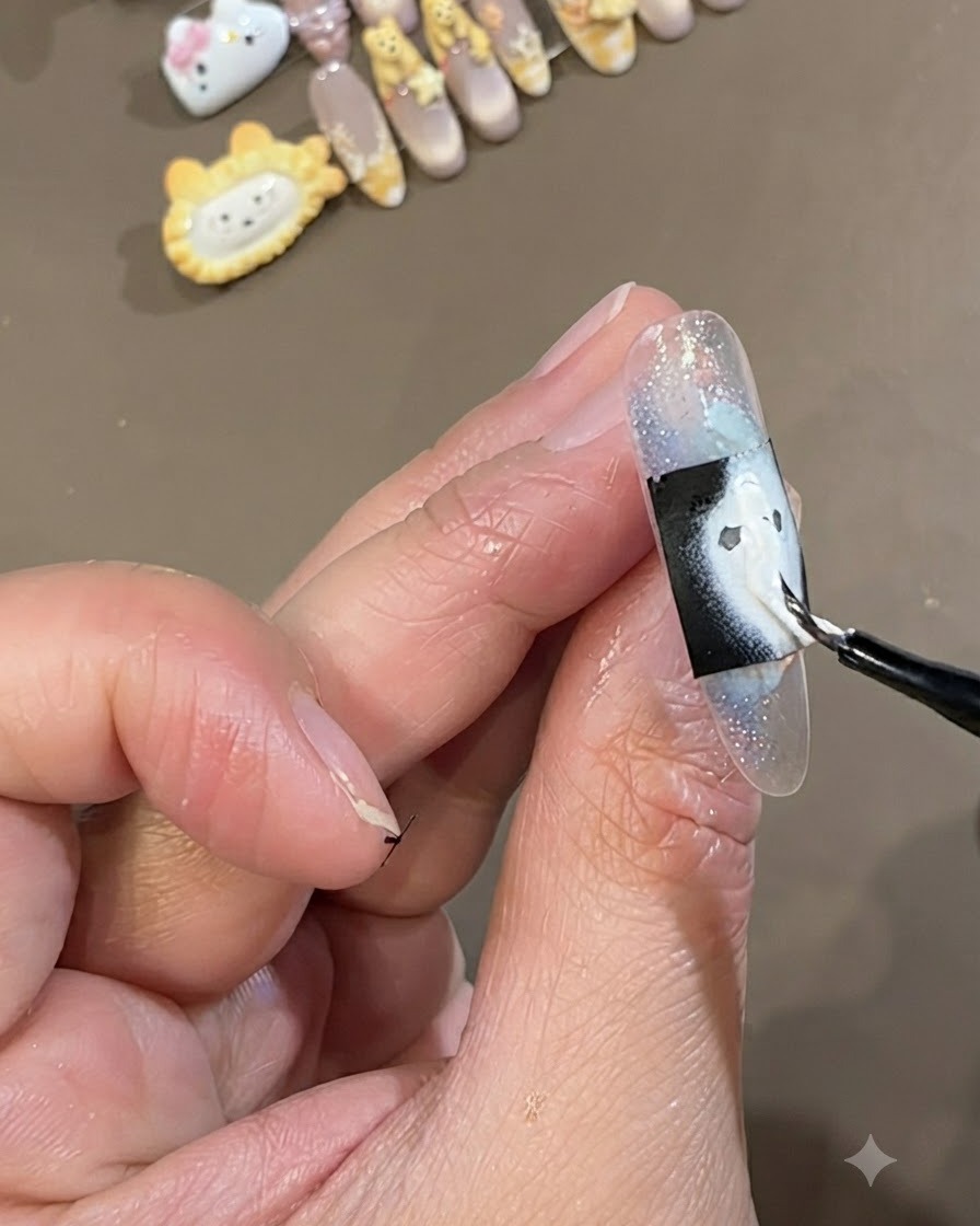 A fine brush painting a thick white gel layer over a rectangular black stencil placed across an icy blue encapsulated nail.