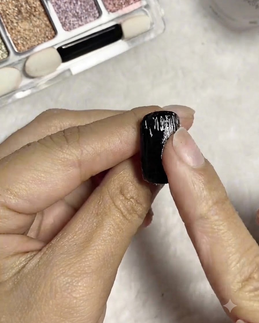 A finger rubbing silver mirror powder directly onto the wet textured lines of the nail.