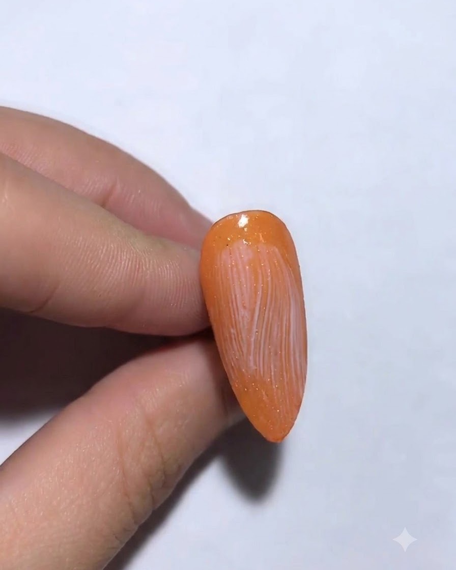 Silver transfer foil being applied and pressed onto a nail.