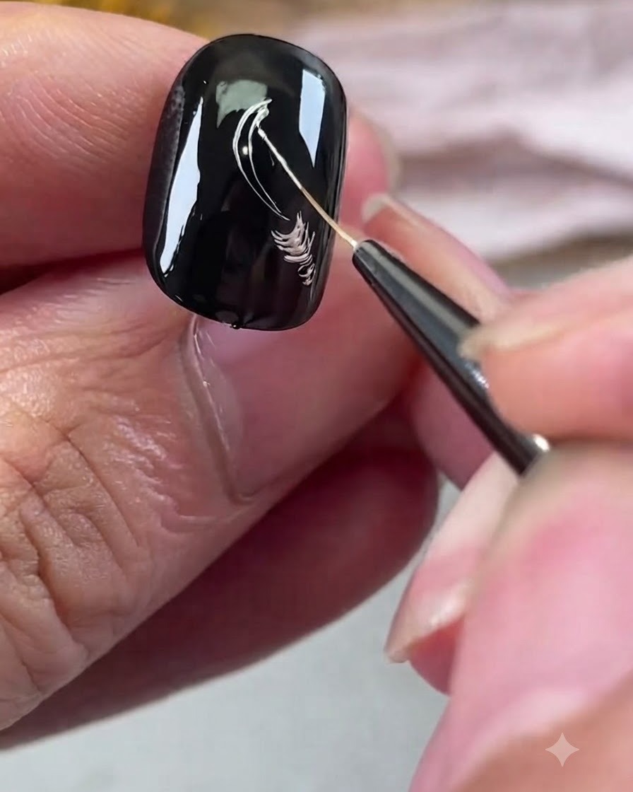 A fine liner brush drawing silver metallic petal outlines on a black gel nail.