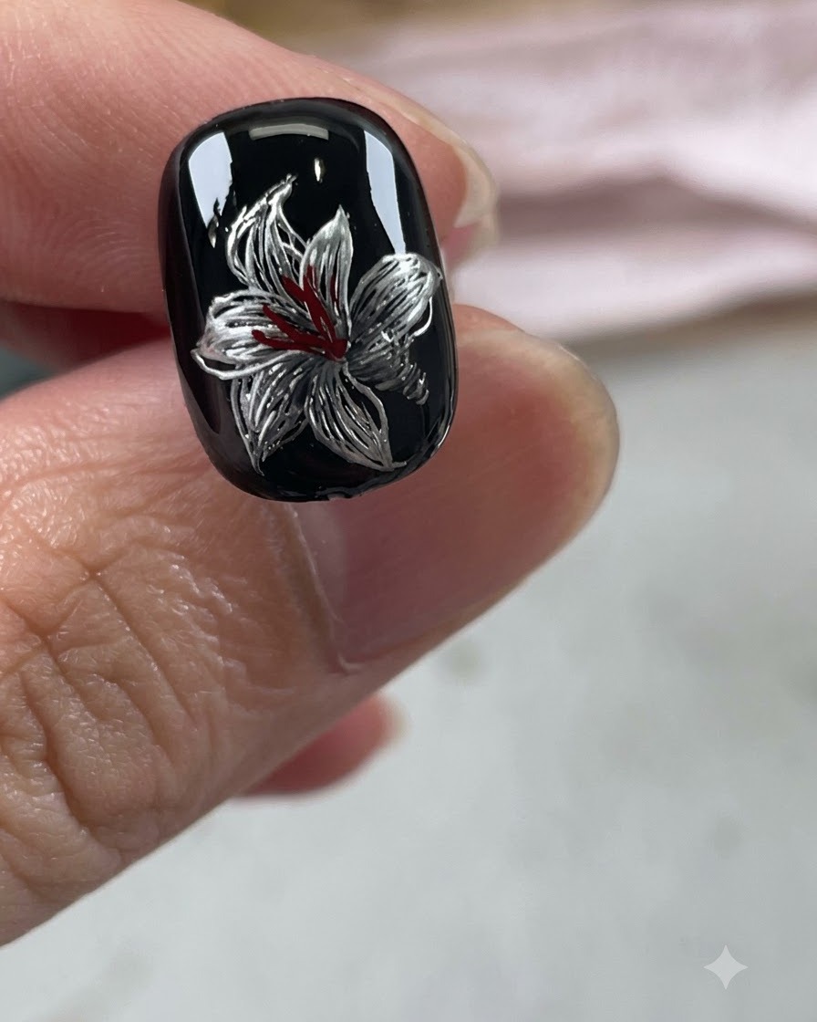 A fine brush adding white highlights and outlines to the metallic silver petals.