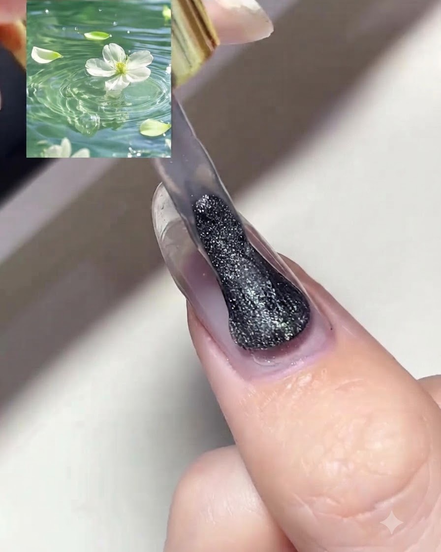 A nail brush applying a coat of shimmery silver magnetic cat eye gel polish onto a prepped fingernail.