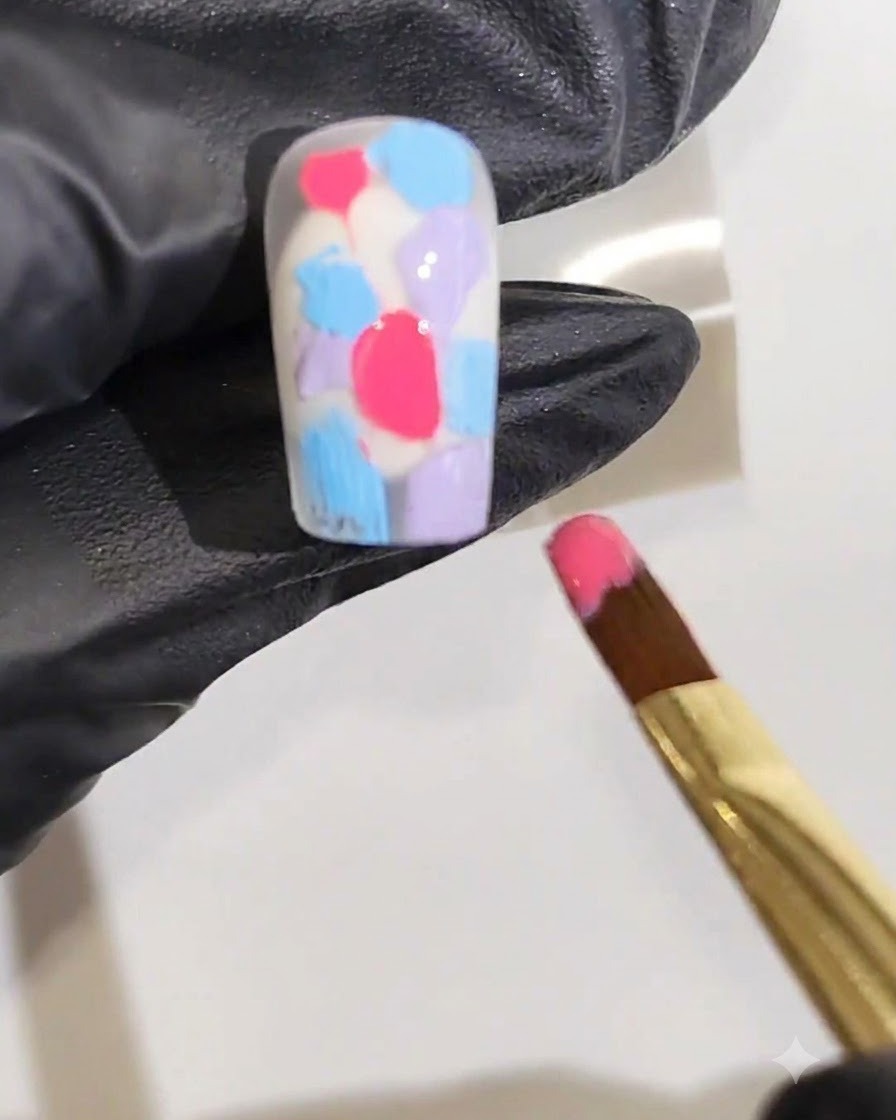 A fine art brush placing a vibrant red gel line down the center of the nail surface.