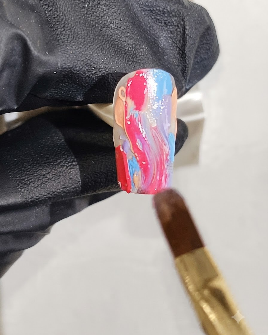 A fine brush applying scattered silver glitter flecks over a wet marble nail design.