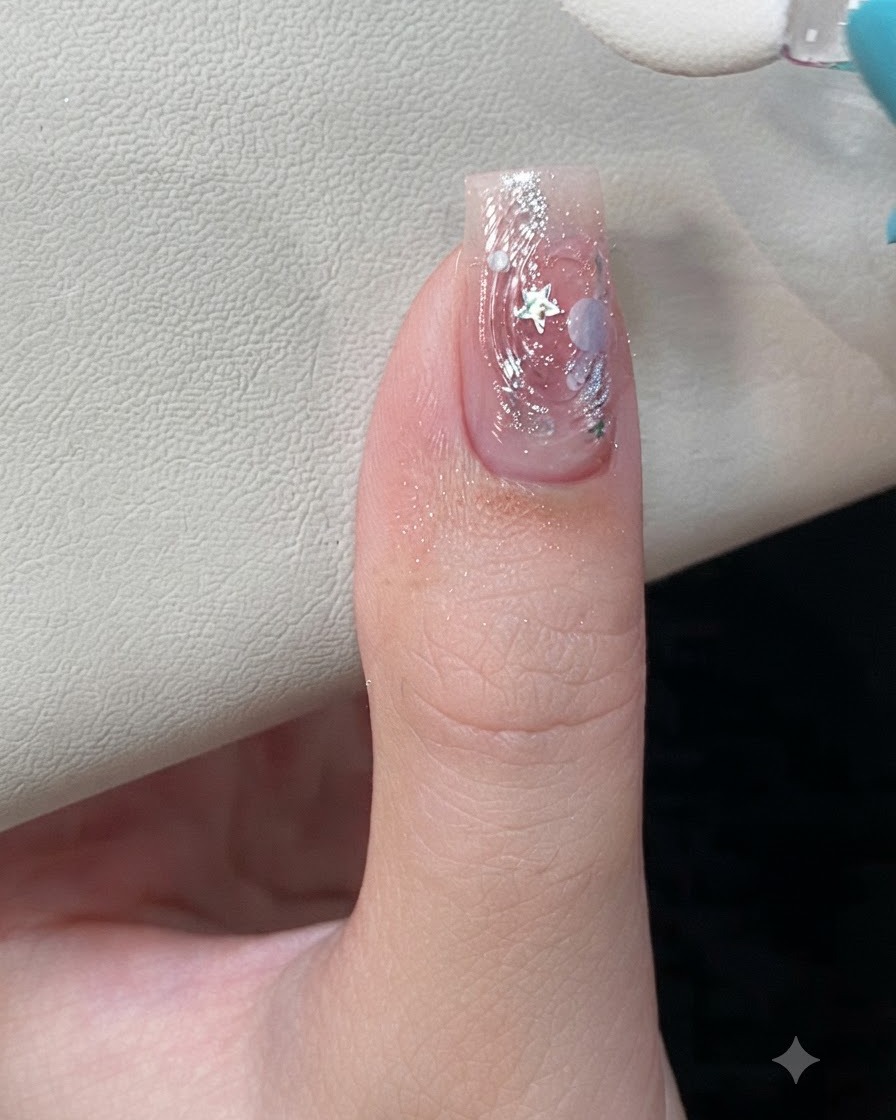 A close-up of a sponge applicator rubbing iridescent aurora powder onto raised 3D water ripple textures on a manicured nail.
