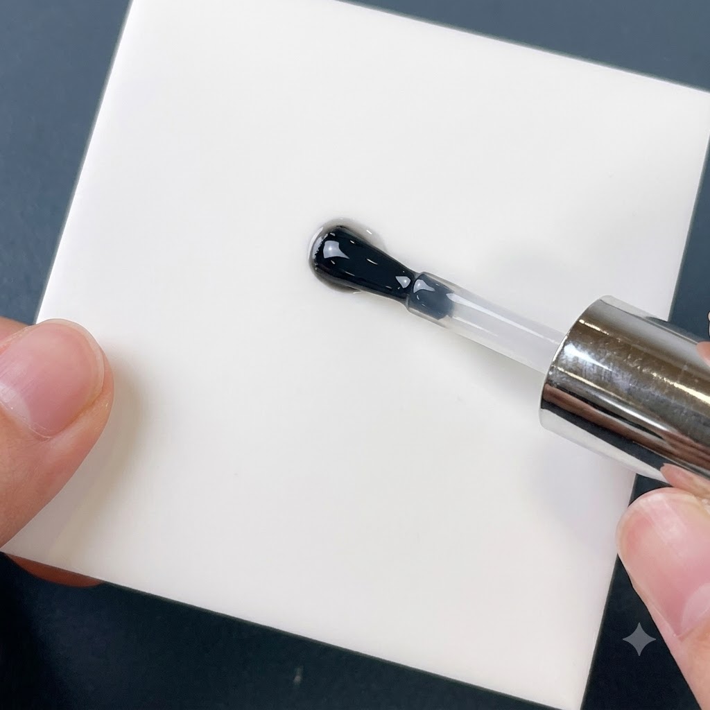 A brush mixing clear reinforcing gel and shimmering powder on a white square palette.