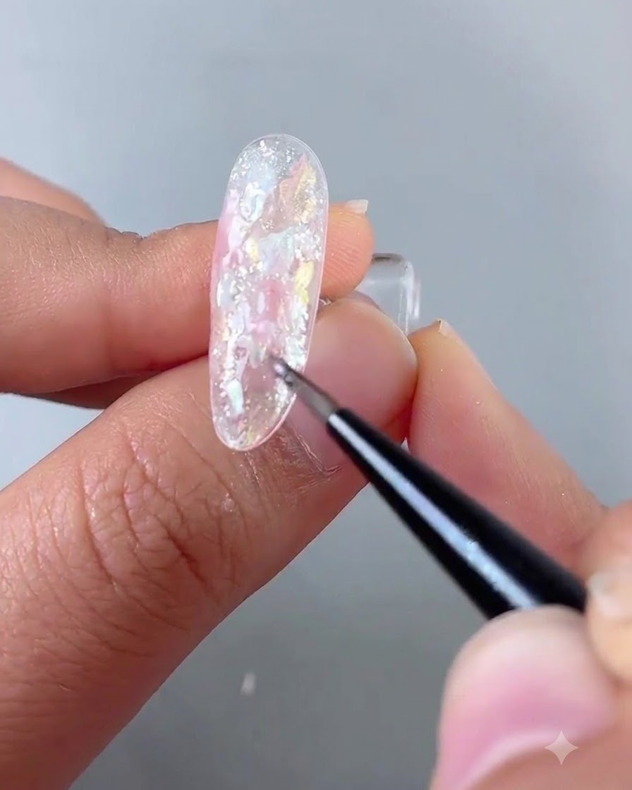 A mini UV flashlight illuminating a freshly painted nail block to set the gel.