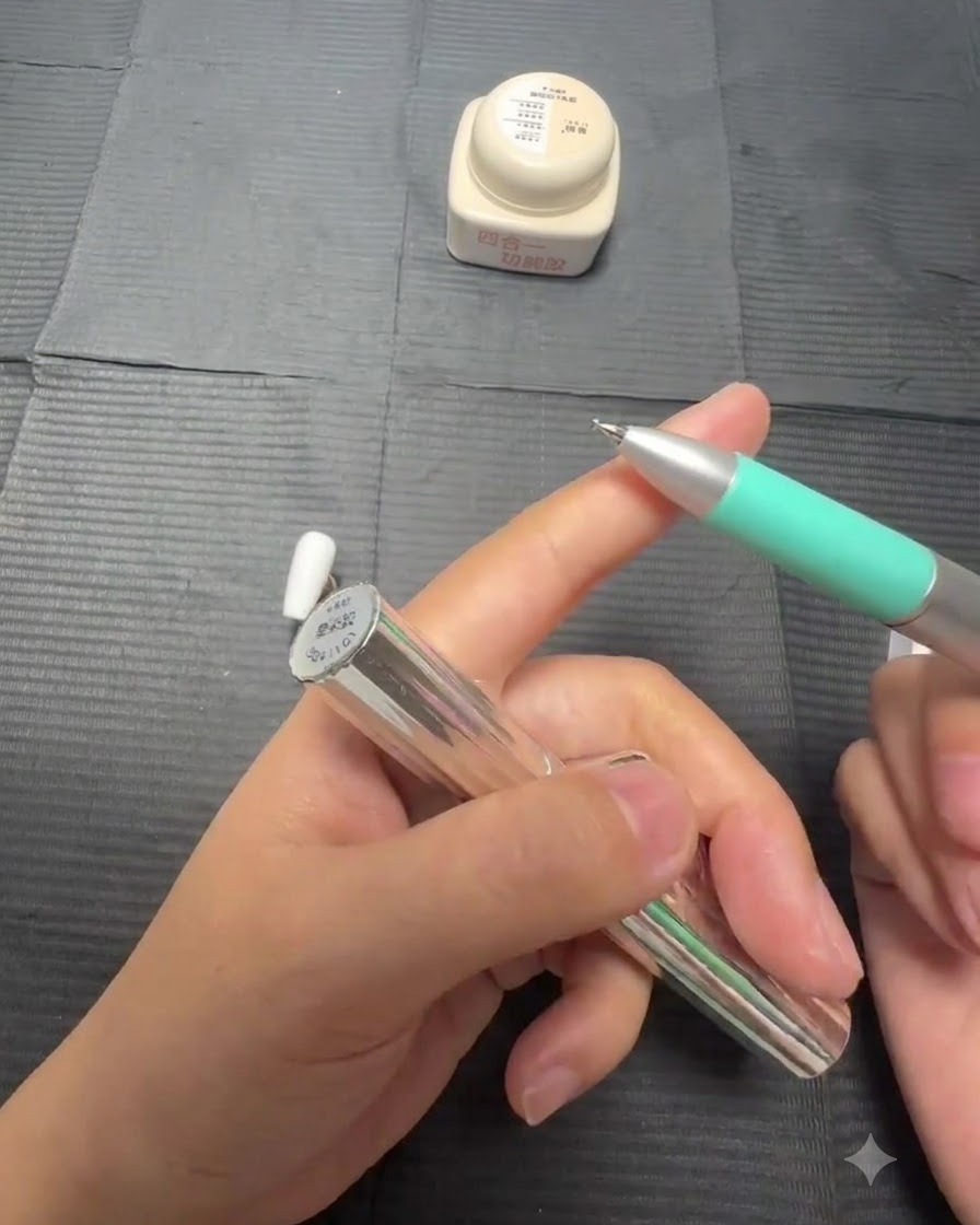 A close-up view of a brush applying clear blooming gel over a white painted nail.