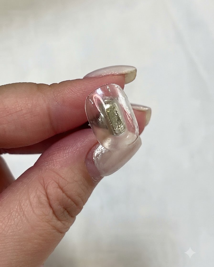 A flat gel brush applying translucent yellow gel onto a nail plate.