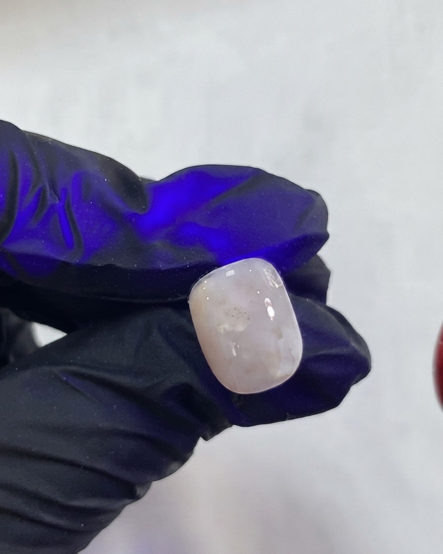 A fingernail curing under a purple UV LED lamp light.