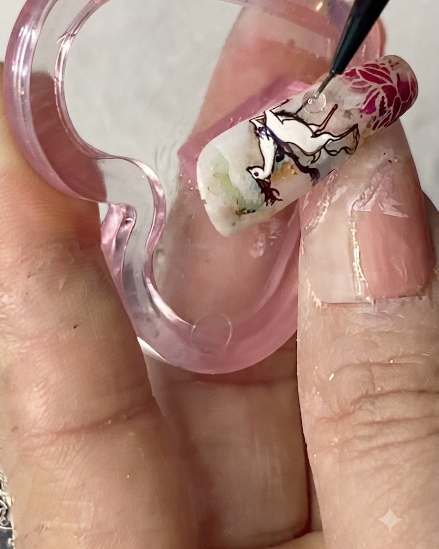 A clear stamper transferring a vibrant, fully colored figure design onto the ring finger nail.