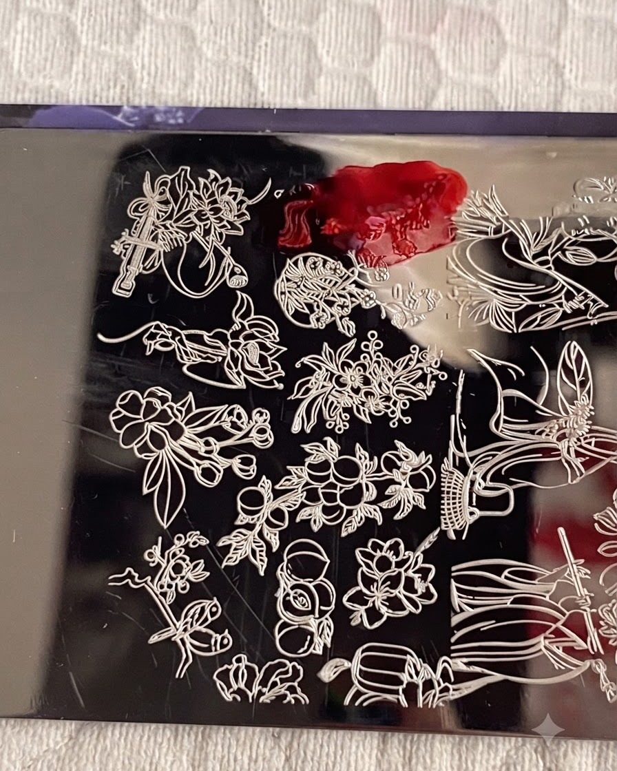 A metal stamping plate with number 1 stamping polish applied over the flower design, and a scraper card removing excess polish.