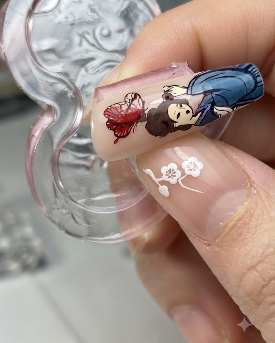 A nail tip with a transferred butterfly design next to a figure character while blooming liquid is applied.