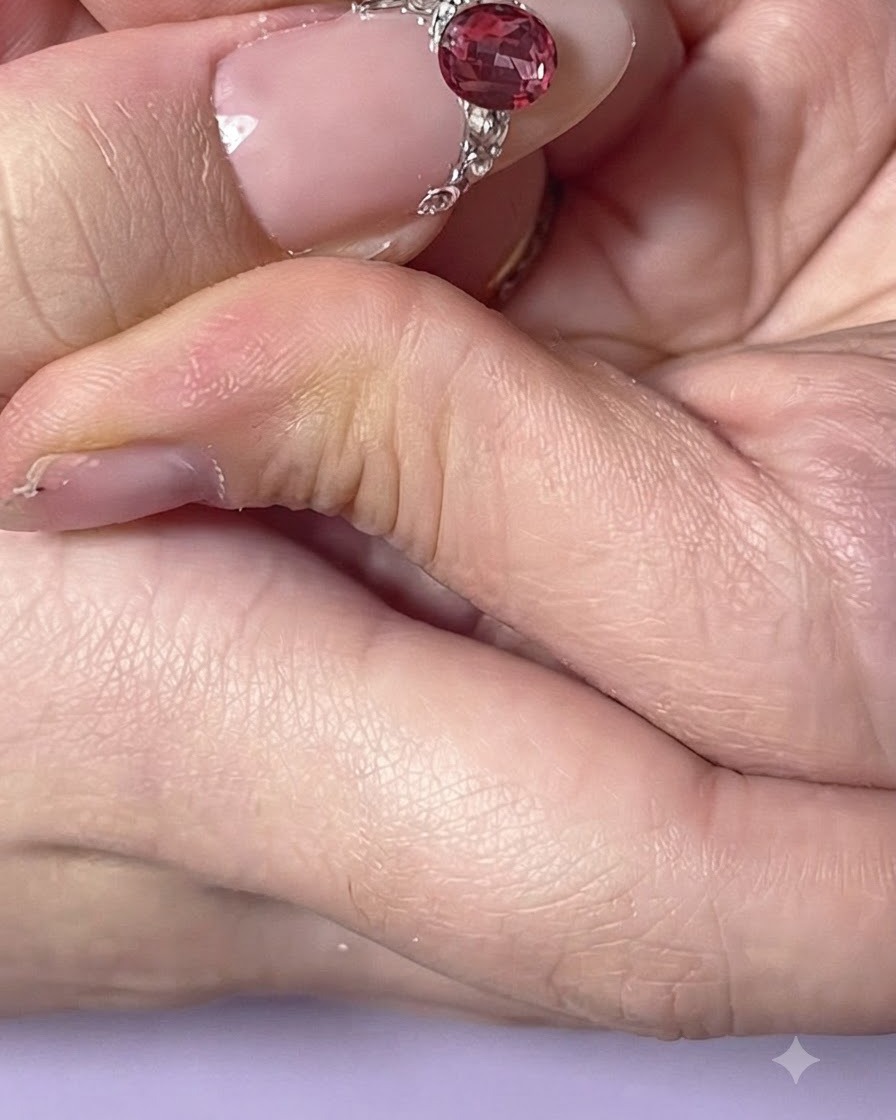 A close-up view of an index finger nail adorned with delicate side rhinestone placements.