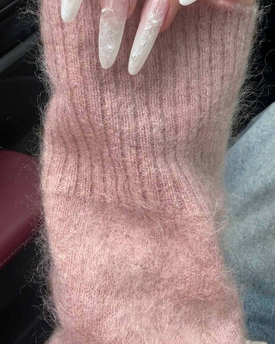 Hand positioned near a car interior showcasing the nails and a matching pearl ring.